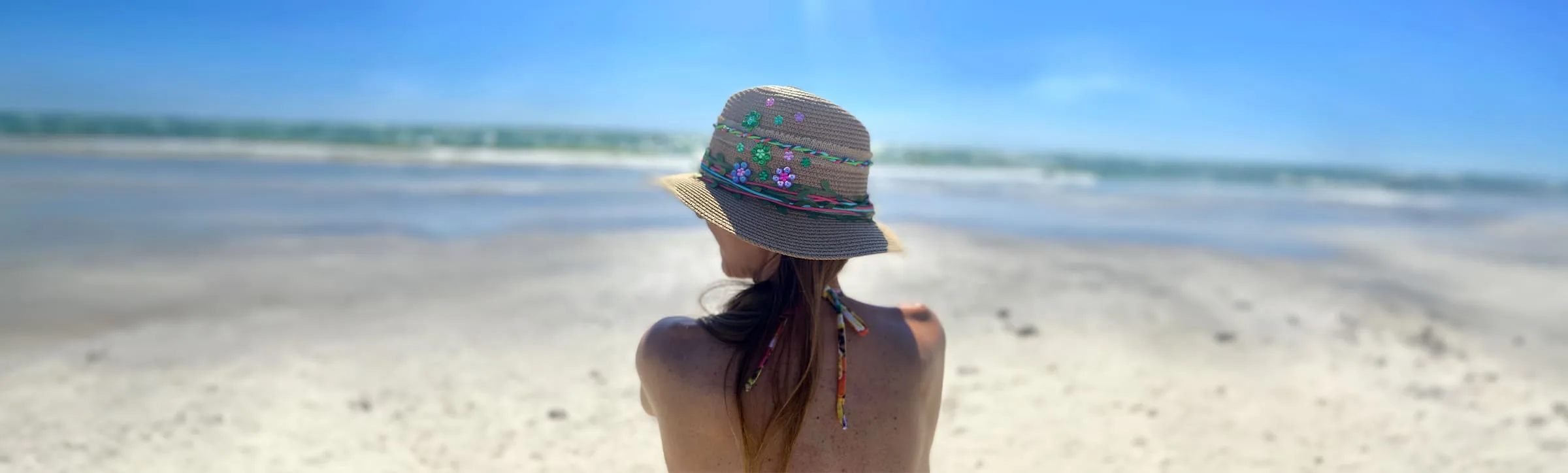 Mujer-sentada-en-playa-en-miami-beach-con-sombrero-fedora (1)
